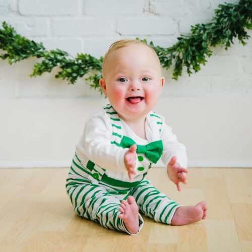 baby wearing a green and white striped baby bow tie outfit from Bebe Couture