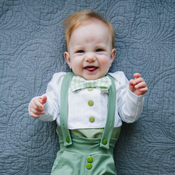 baby wearing a sage green baby bow tie outfit