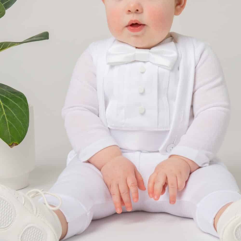 baby boy wearing a white blessing outfit with bow tie